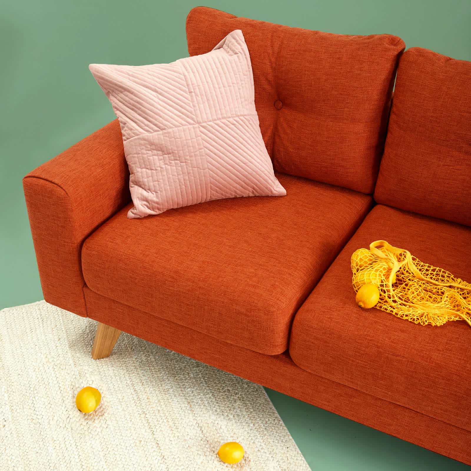 Compact living room with cream sofa, terracotta pillows and layered decor